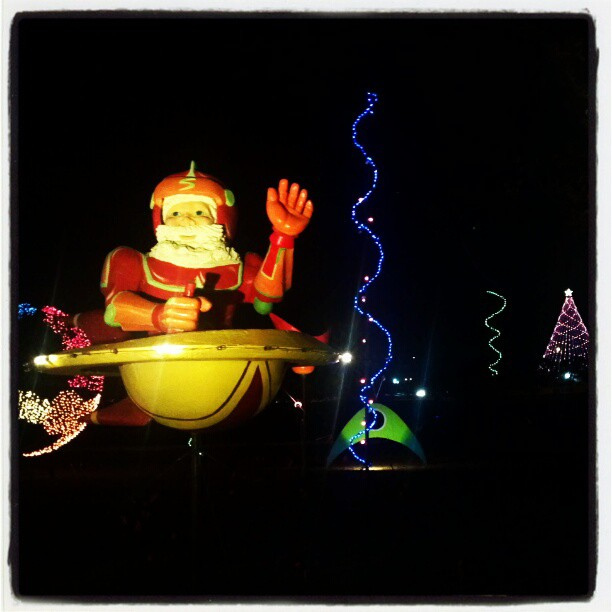 A night photo of a big anamatronic Santa in a space ship