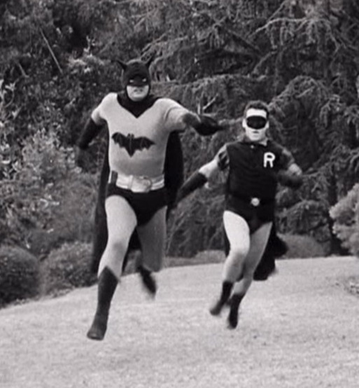 A grainy black and white still frame of Batman and Robin running towards the camera from the 1949 Batman and Robin serial